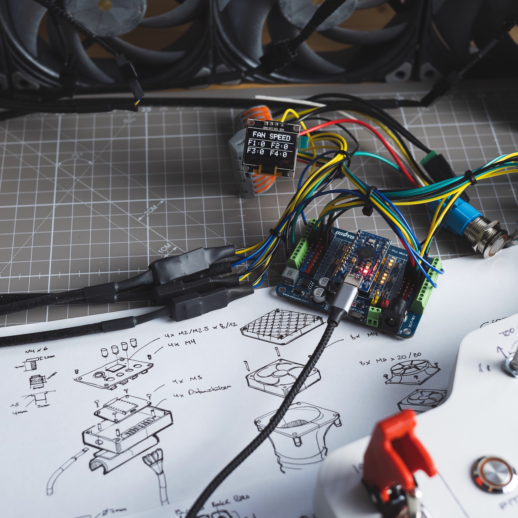 YTEM fan controller on the bench, the board wired up and running beside the sketches it was built from